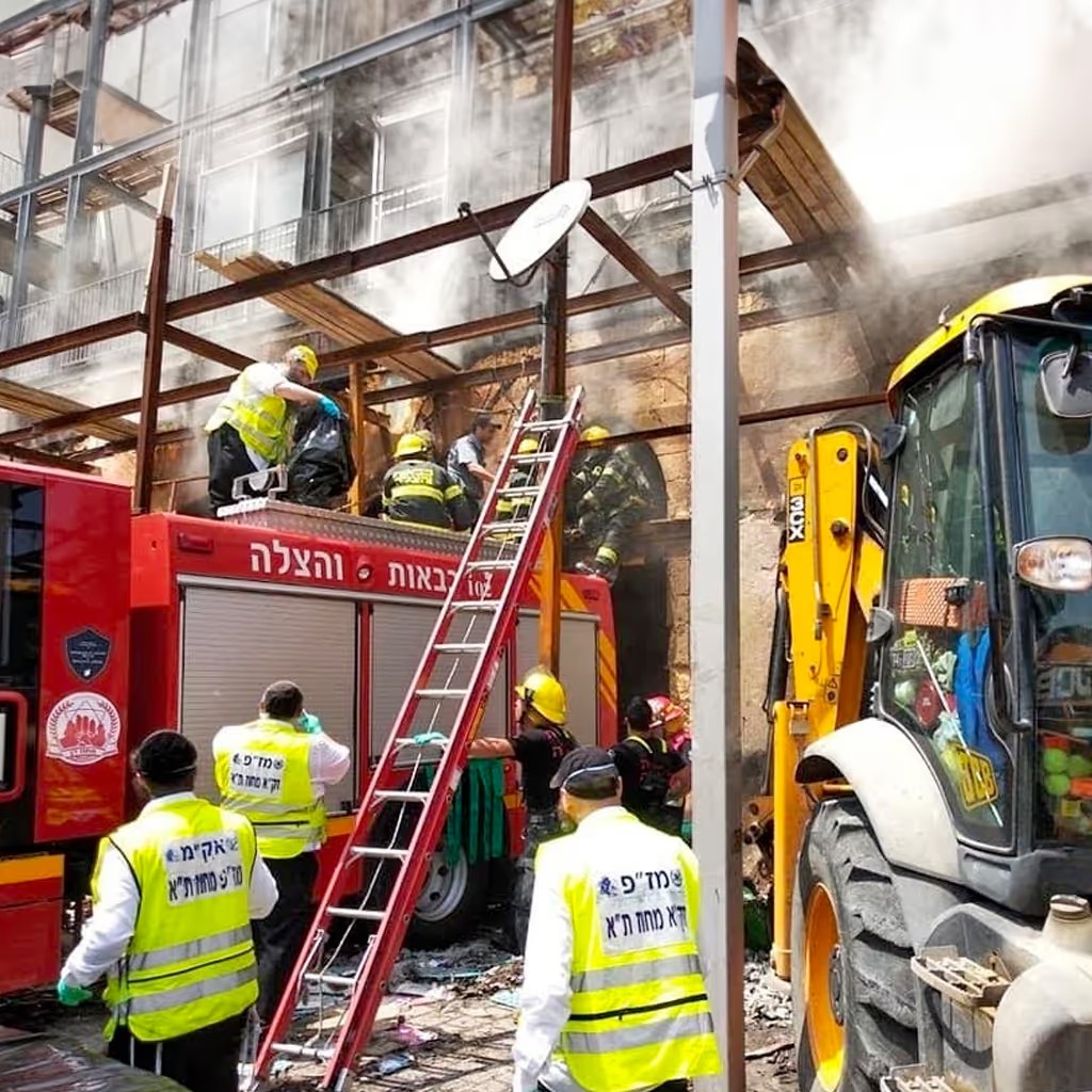 ZAKA Tel Aviv volunteers and firefighters work a fire and rescue scene together.