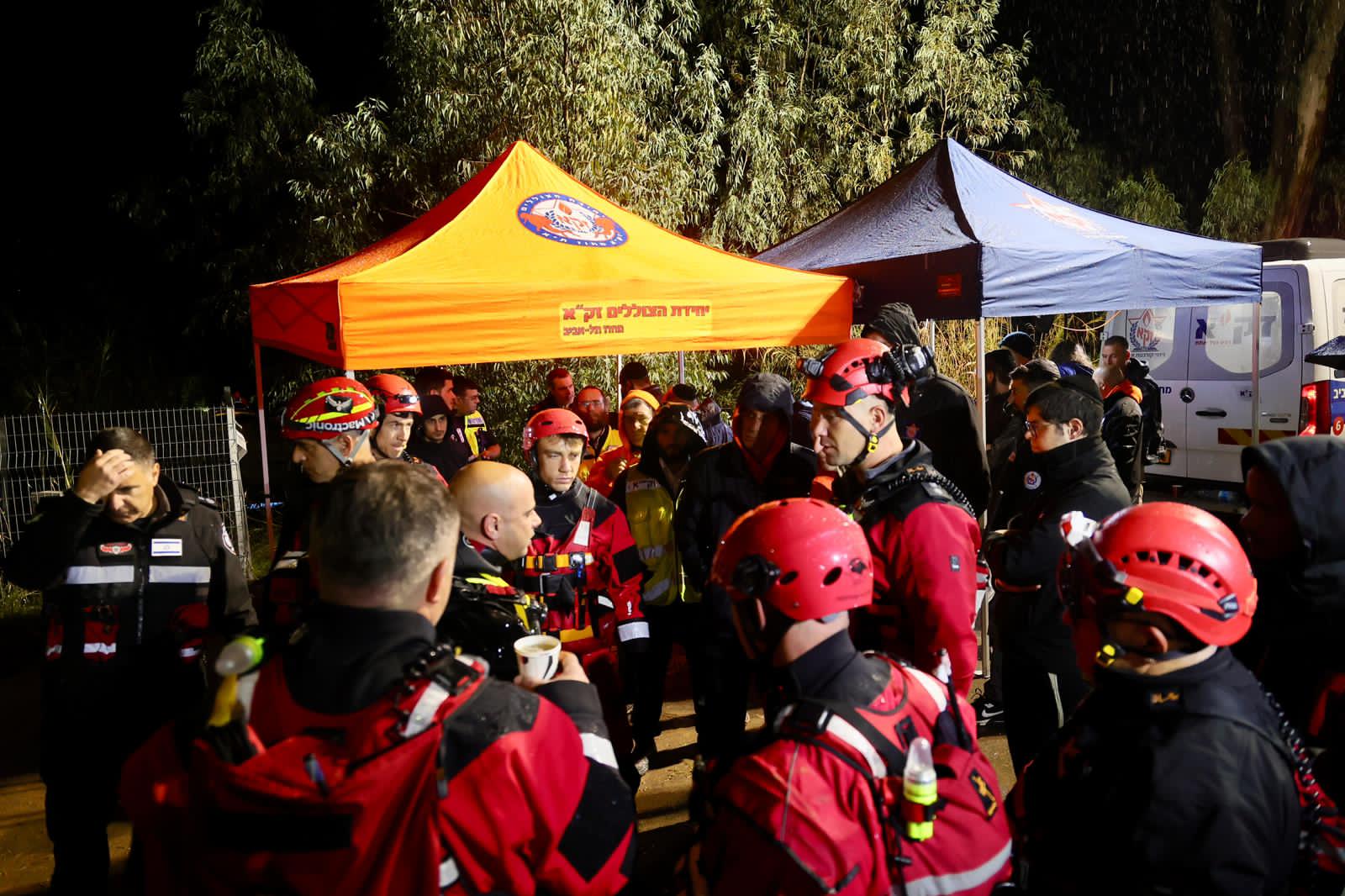 ZAKA teams regroup at a staging point after dark.
