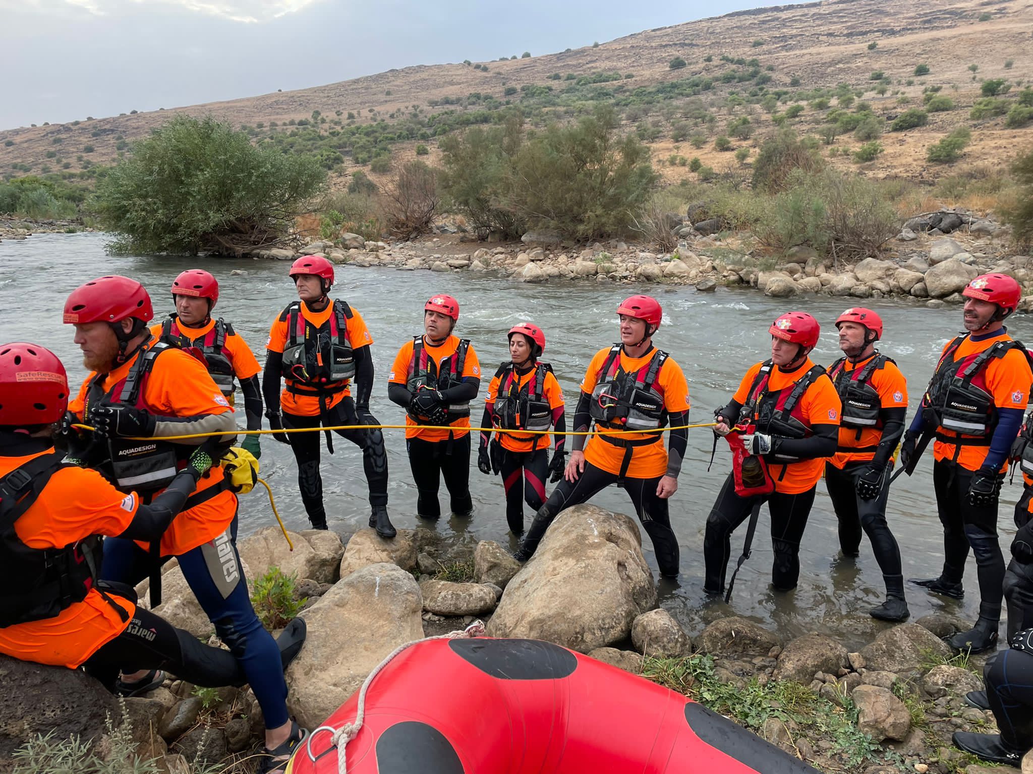 A ZAKA water rescue team gathers at a riverbank before a search.
